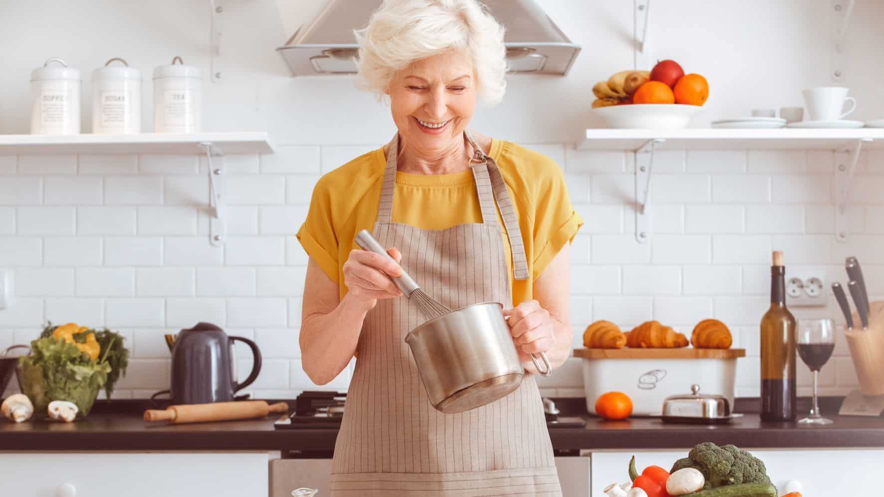 Middle-aged woman cooking in her kitchen. She is stirring a pot.