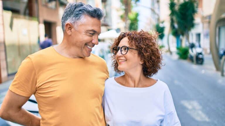 Hispanic man in yellow shirt smiling at a Hispanic woman in white shirt