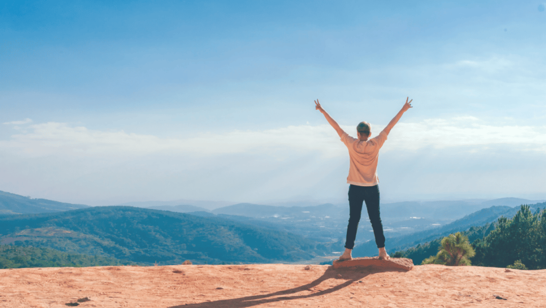 Woman Looking At Mountains With Arms Up