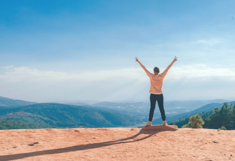Woman Looking At Mountains With Arms Up