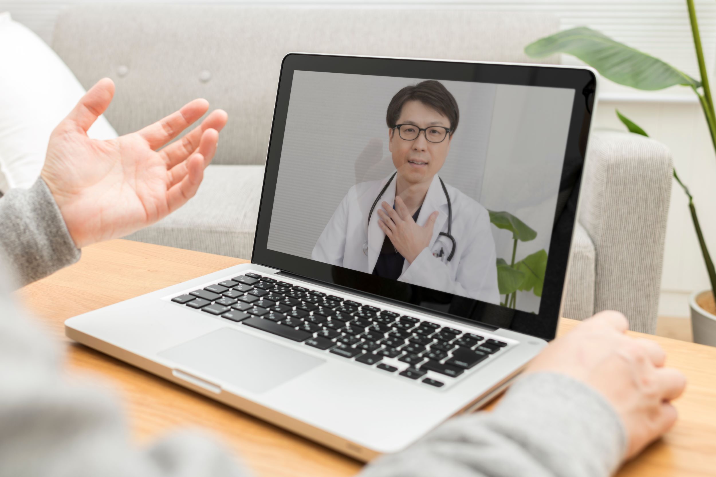 Person talking to a doctor for a virtual healthcare visit on a laptop