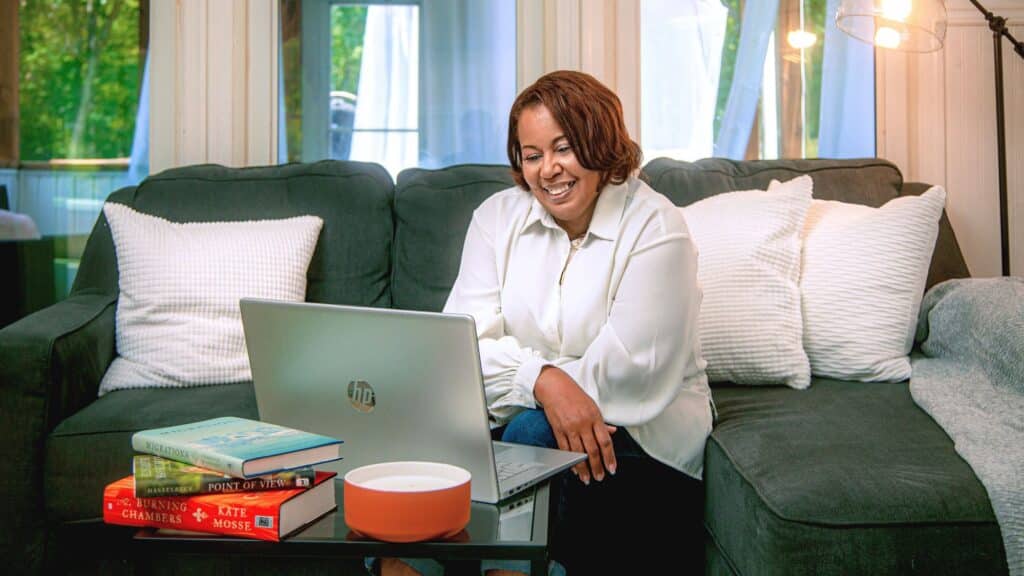 Woman sitting on her couch in front of her laptop