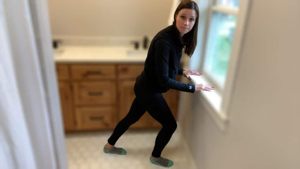 Calf stretch being demonstrated in a bathroom