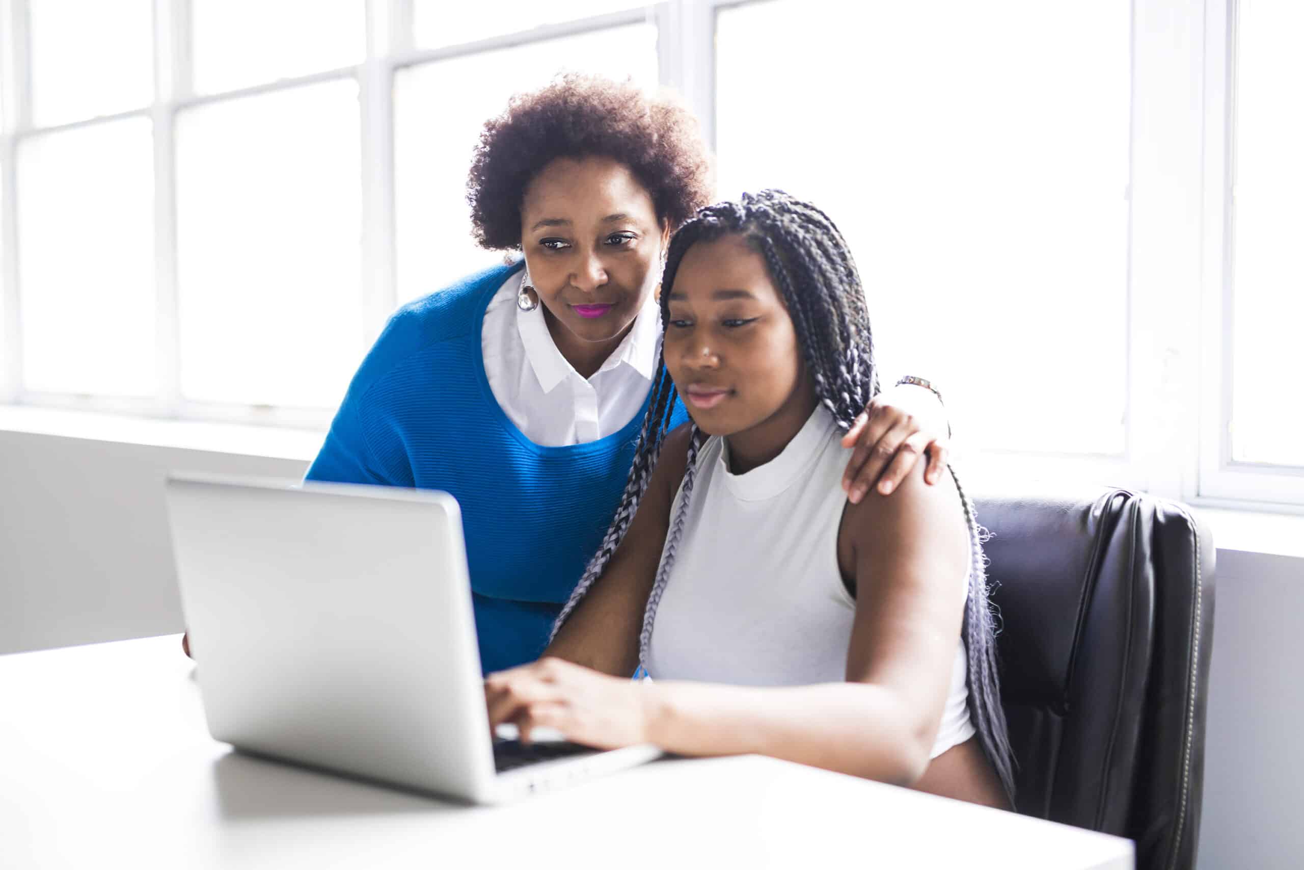 Young woman and her mother watch a webinar