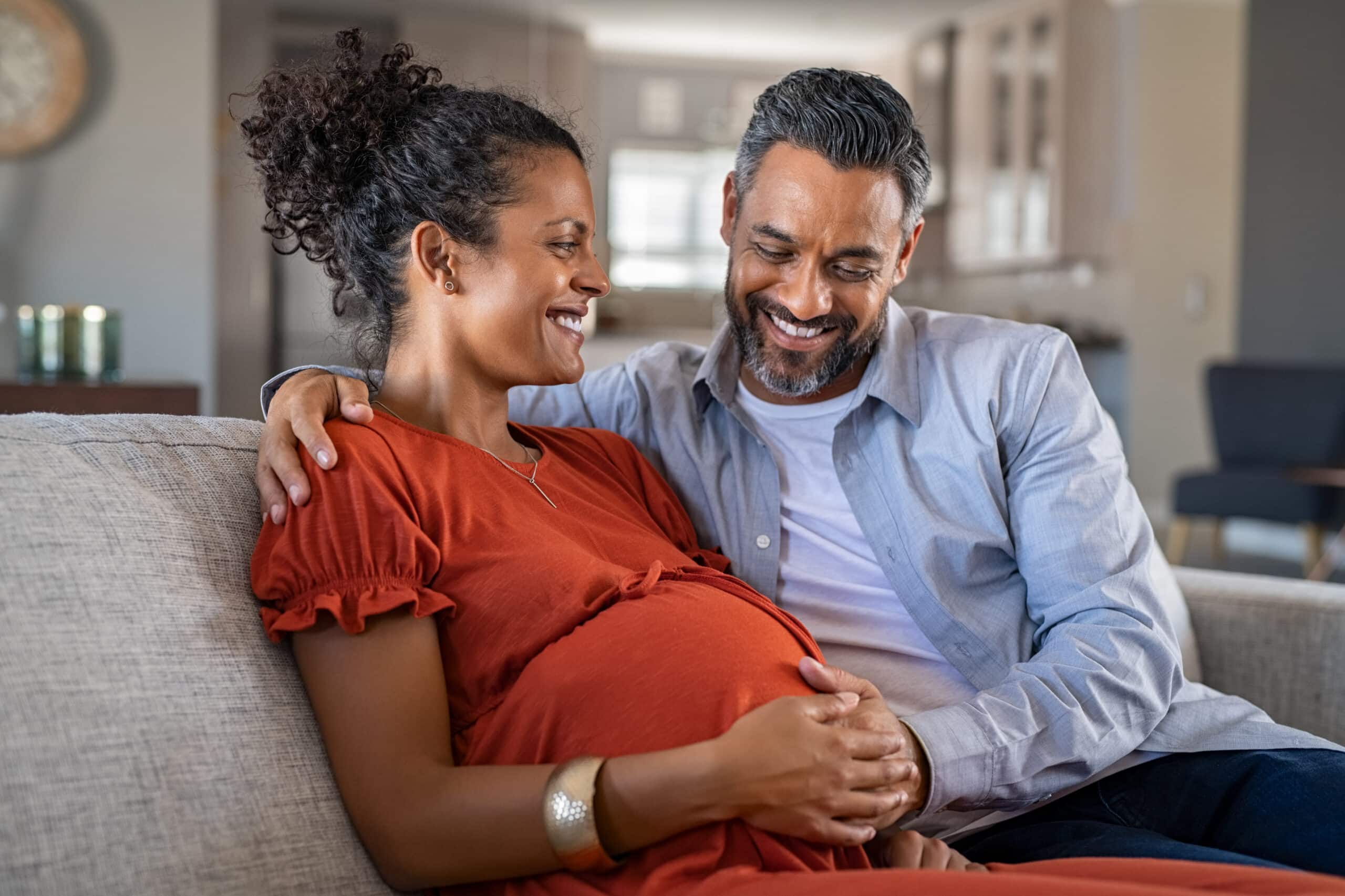 Pregnant Woman And Husband on Couch Smiling, MS and Pregnancy