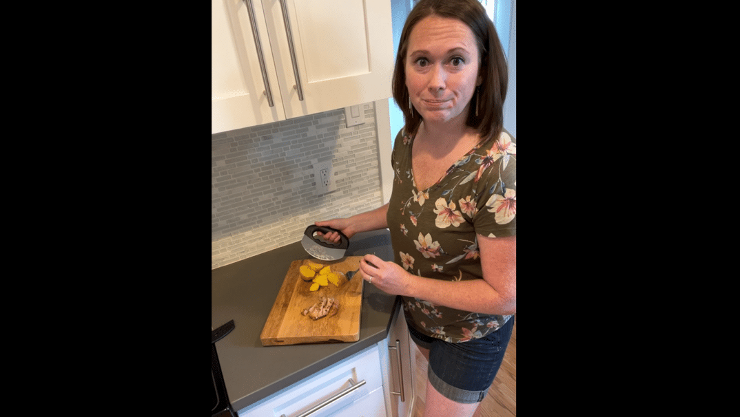 Occupational Therapist, Stephanie Nolan standing in her kitchen holding a rocker knife