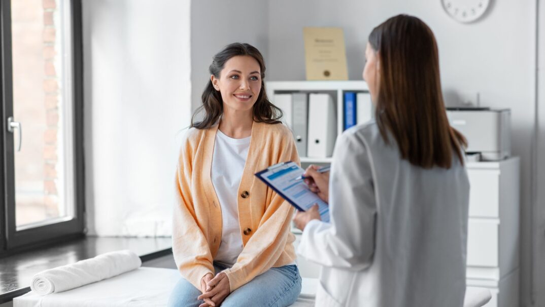 doctor with younger patient talking in exam room