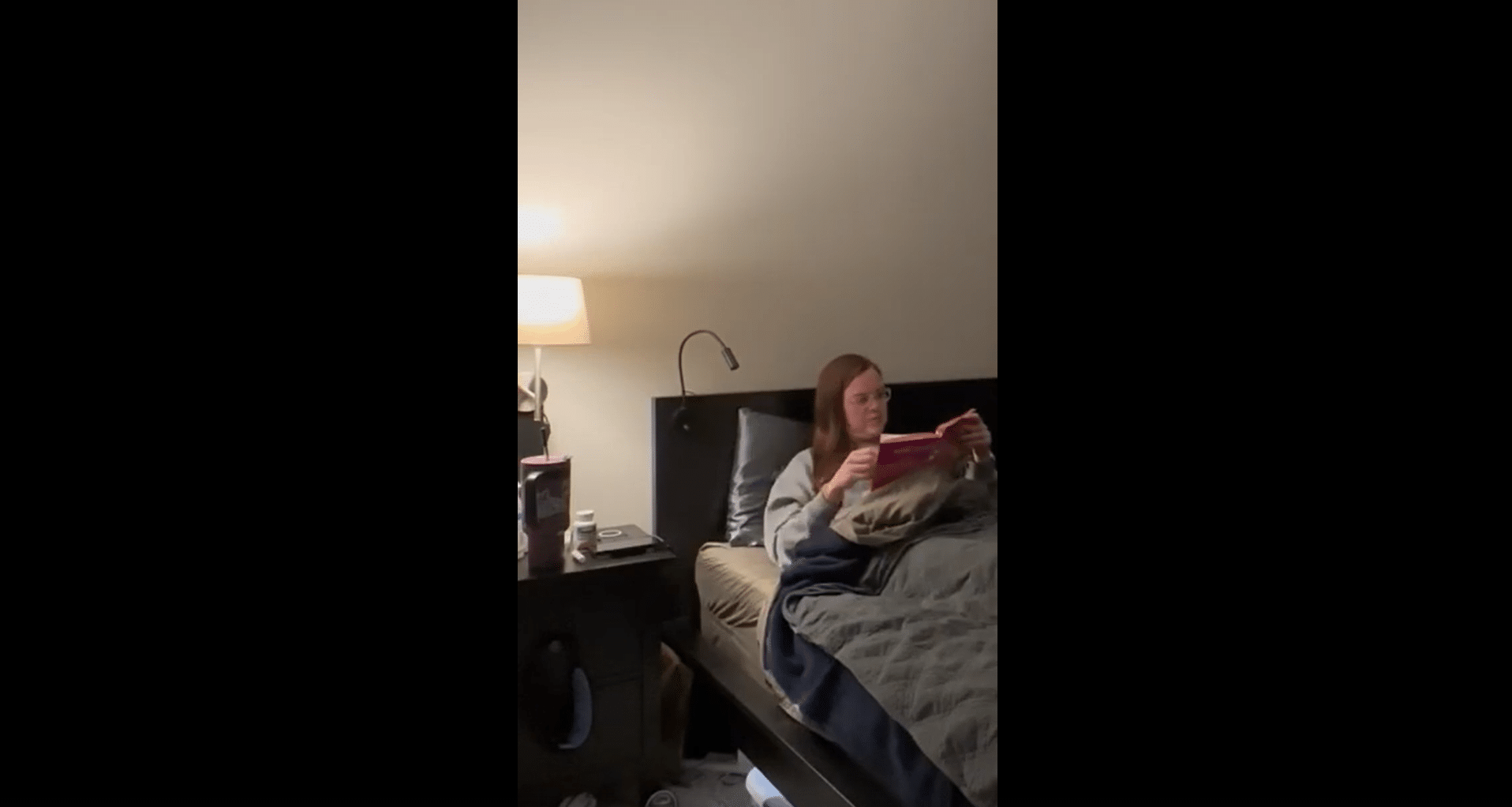 Emily Reilly sitting in bed reading a book.