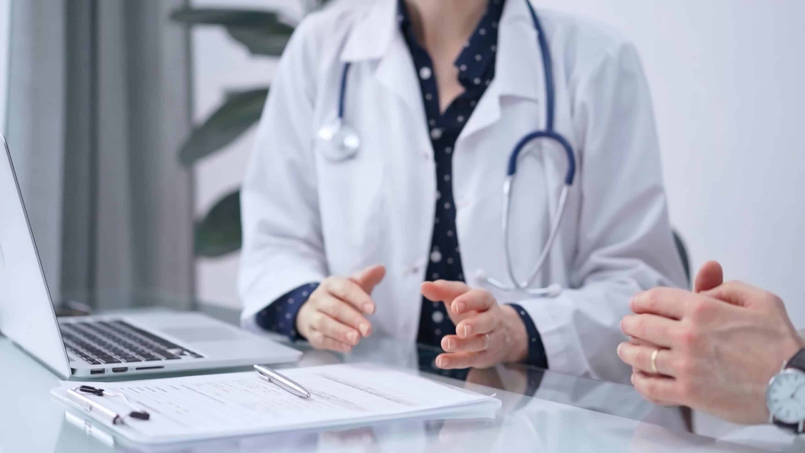 Female doctor speaking to another health care professional. There are no faces shown in this image.