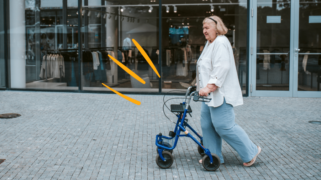 Woman using a rollator on a sidewalk.