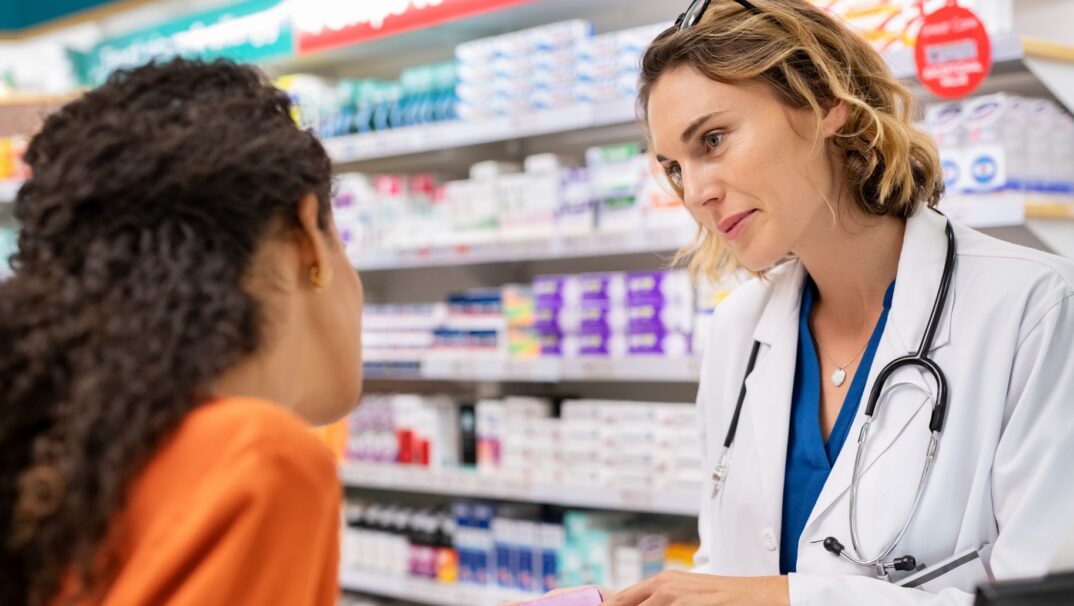 Pharmacist talks to a young woman at the pharmacy.