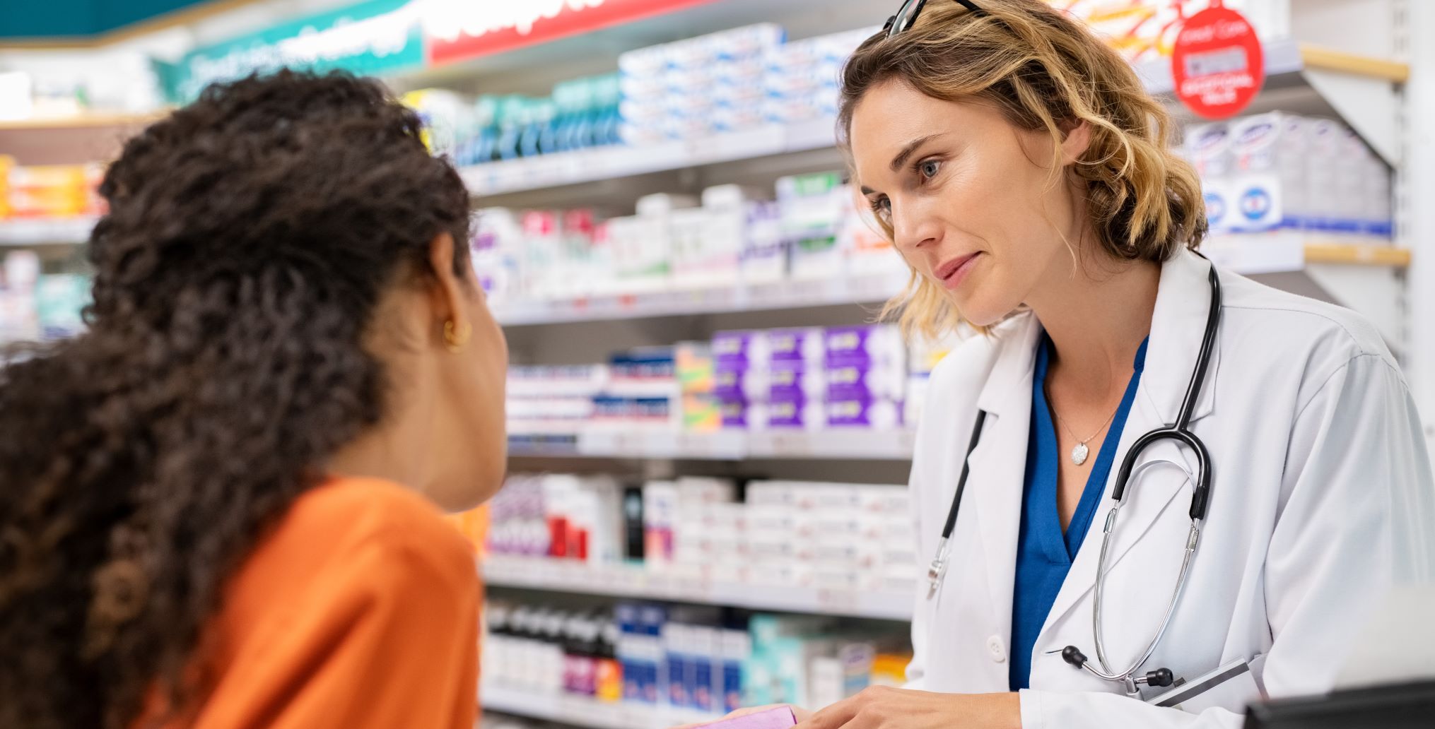Pharmacist talks to a young woman at the pharmacy.