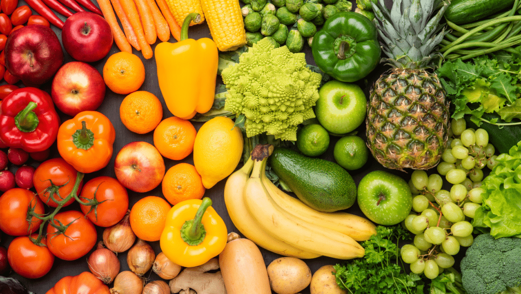 An assortment of foods in a gradient the colors of the rainbow.