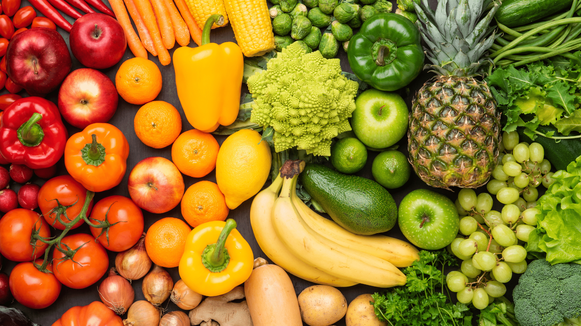 An assortment of foods in a gradient the colors of the rainbow.